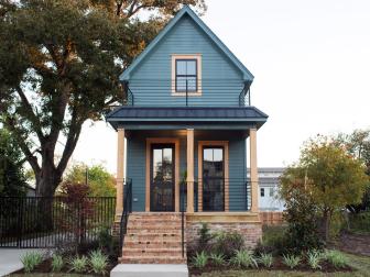 Dark Green Shotgun Style Home with Metal Roof, Brick Skirt and Iron Railings
