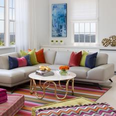 Eclectic Living Room With White Background Mixed With Bright Colors and Patterns and Neutral Leather Sofa 