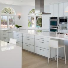 Modern Monochrome White Kitchen With Large Island and Stainless Steel Appliances 