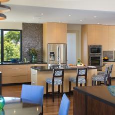 Bright Contemporary Kitchen With Light Wood Cabinets, Patterned Bar Chairs and Textured Brown Backsplash 