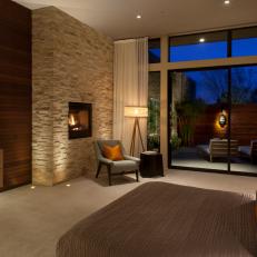 Modern Master Bedroom With Textured Brick Fireplace Surround, Large Glass Patio Doors and Calm, Neutral Color Scheme 