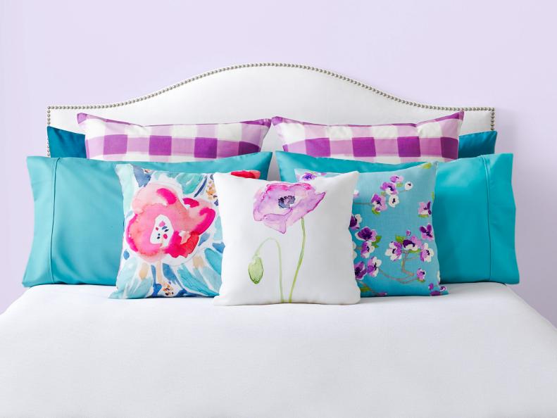 White Studded Headboard With Purple And Turquoise Pillows