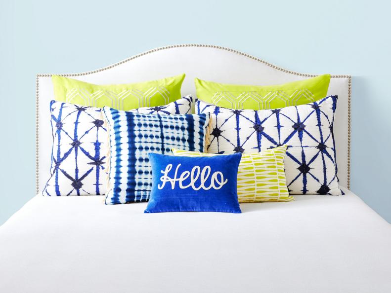 White Studded Headboard With Blue And Green Pillows
