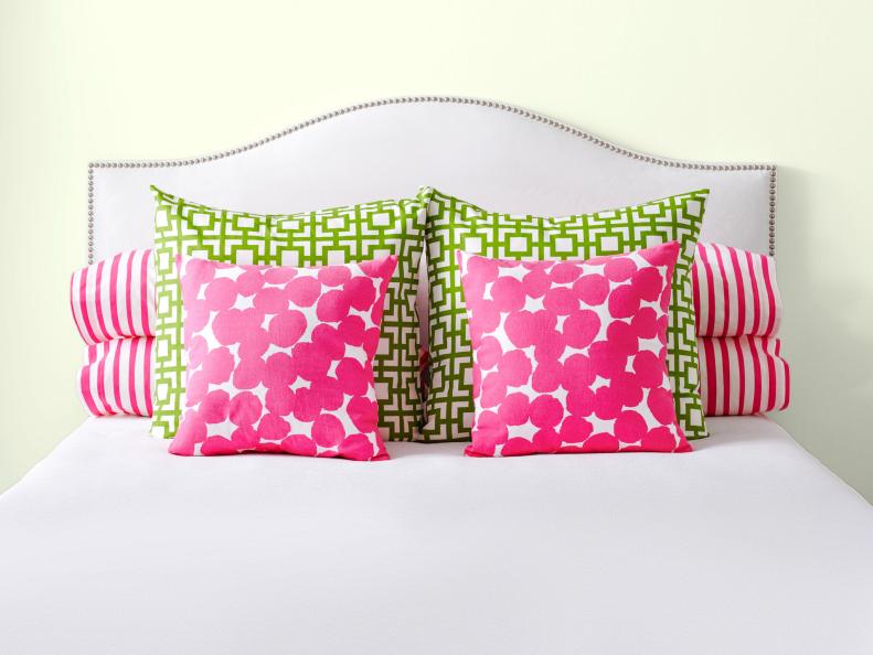 White Headboard With Green And Pink Pillows