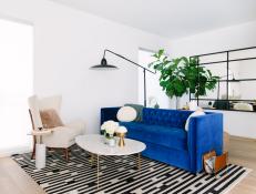 A California townhouse was given a contemporary, feminine feel through the use of vibrant blue and gold furnishings and accessories. Irregularly shaped rooms feature workable layouts that live larger than their footprints.