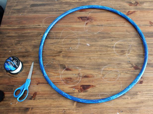 Cut five 24” lengths of fishing line and tie them to the hula hoop equal distance from each other.