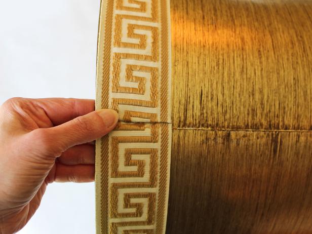 Easily turn an old trashed lampshade into a trendy treasure just by attaching upholstery tape trim.