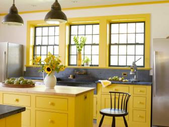Interior Designer Heide Hendricksâ   color sense hits the perfect pitch in this kitchen. â  The surrounding meadows filled with Goldenrod and Black-Eyed Susan helped choose the colors,â   she says. Hendricks collaborated with her husband Rafe Churchill on this country home for a family of four. Cabinetry painted in Farrow & Ballâ  s â  Baboucheâ   yellow compliments the dark grey of custom-fabricated soapstone sink and counters. Added to the softly textured white of rubbed plaster walls and ceilings, and vintage plumbing and light fixtures, the space feels traditional, yet fresh.