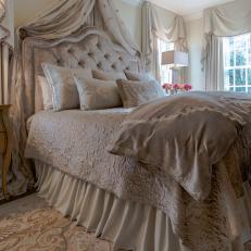 Lavish Victorian Bed With Textured Neutral Bedding, Tufted Headboard and Decorative Hanging Drapery 