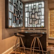 Contemporary Home Bar With Custom Back-Lit Shot Glass Storage, Tall Barstools and Stone Flooring 