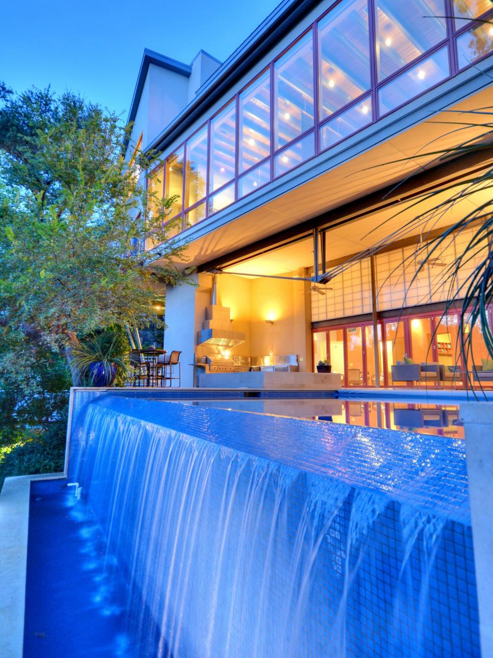 contemporary swimming pool with waterfall at night hgtv