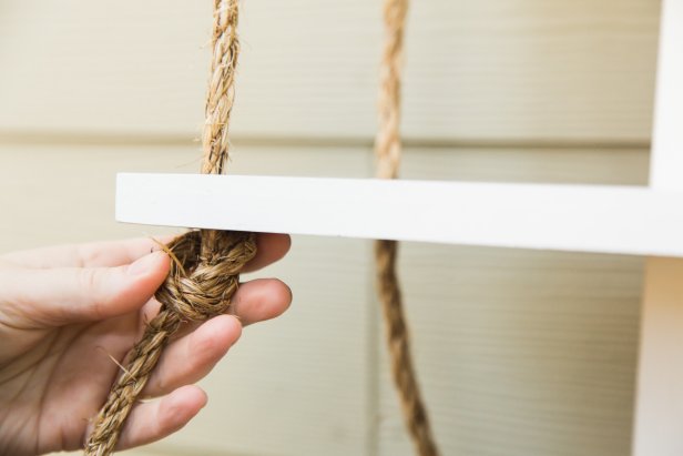 Once the bottom shelf is hung, tie off the ropes into a knot on either side, then trim them with a utility knife. For an interesting texture, you can pull apart the ends of the ropes for a fringed look. Now you’re ready to hang the shelf- just be sure to use the proper hardware and anchors! HINT- If you hang the shelf in a bathroom, over time the steam will help the rope straighten out a bit!