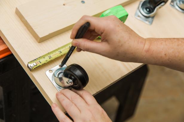 While the base is still flipped upside down, install the casters on each corner. First, measure and mark for placement- 1 inch from each edge. Next, fasten using #10 1” wood screws.