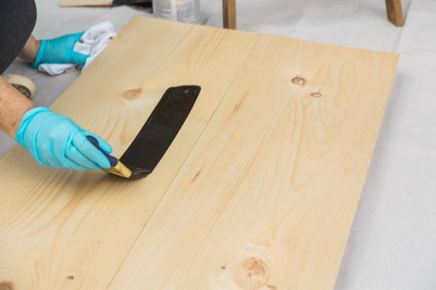 Next, flip the base right side up and move it onto a drop cloth for staining. Brush on the stain then wipe off with a rag you may need to use a fresh rag as you work. Set the base aside to dry and move on to the pipe part of the project.