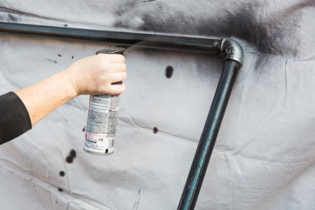 Once the rack is fully assembled, move it to a well ventilated area and give it a couple of light sweeping coats of a dark bronze finish paint. Spray paint the entire pipe (elbows, flanges and all!) then allow it to dry completely before moving on to the next step.