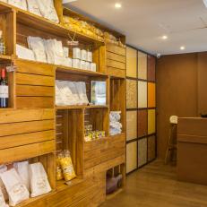 Restaurant Host Stand With Wood Crate Shelving Storing Wine and Goods and Decorative Neutral Tile Wall 