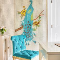 Contemporary Sitting Space With Vivid Pop of Blue on Tufted Chair and Tropical Peacock Wall Decor Over Textured Carpet 