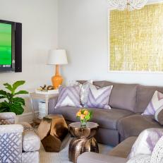 Fun Contemporary Living Room With Large Gray Sectional, Gold Geometric Coffee Tables and Orange Table Lamp