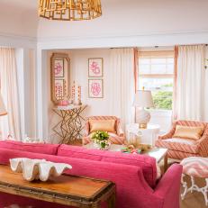 Pink Accent Tones in Transitional Living Room With Red Sofa, Striped Armchairs and Gold Embellishments 