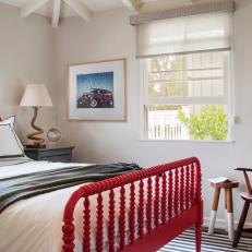 Country Bedroom With Bright Red Bed Frame, Black and White Bed Linens and Simple Wood Chair
