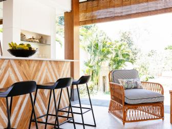 Coastal Outdoor Bar and Sitting Area With Black Barstools & Cushioned Armchair