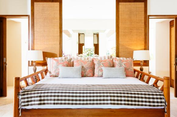 White Coastal Bedroom With Brown Wood Accents and Coral Pillows