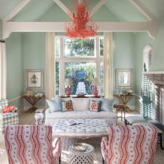 Mint Green Shabby Chic Living Room With Coral Chandelier, Large Tufted Coffee Table and Wavy Striped Arm Chairs