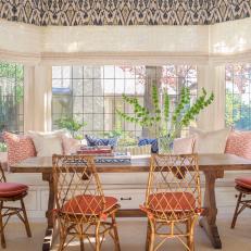 Bright Cottage Dining Room With Window Bench Seating, Bamboo Chairs and Blush Pink Accents 