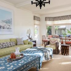 Open Design Cottage Living Room With Two Large Blue Coffee Tables and Green Patterned Sofa