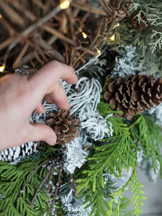 Step 2:  Assemble Greenery and SphereSet a wreath, top-side-up, on top of each urn or planter pot.  Tuck fresh or faux greenery, sprigs, sprays and/or berries into wreath.  Florists wire or hot glue can be used to secure sprigs, if necessary.  Set grapevine sphere on top of wreath, tucking battery packs inside of urn.  Turn on lights and enjoy the beautiful display that took only minutes to create!