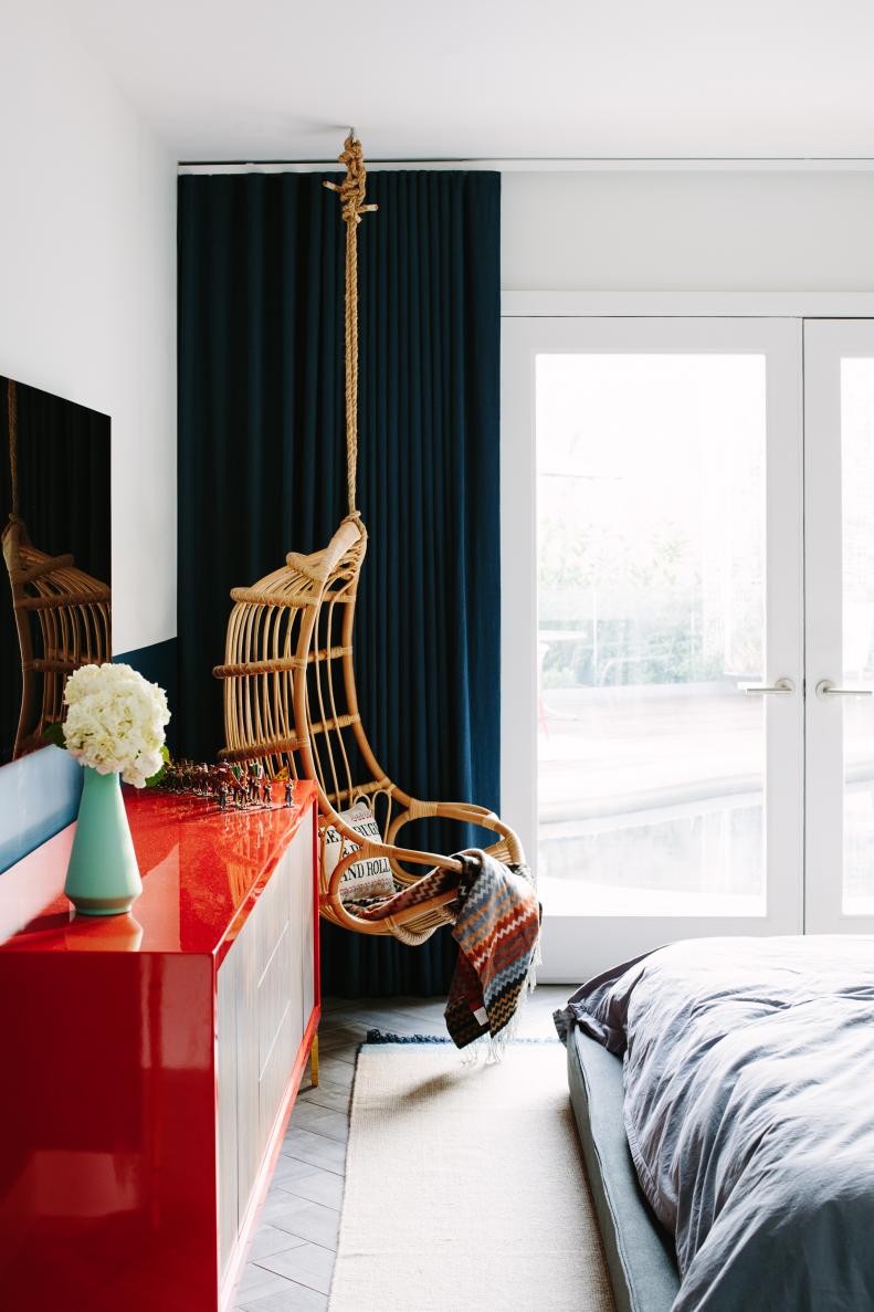 Bedroom With Hanging Rattan Chair and Red Desk