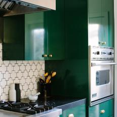 Bold Kitchen With Forest Green Cabinets and Gold Metal Accents