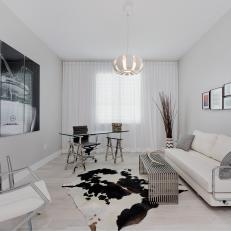 Monochromatic White Modern Living Room With Animal Hide Rug, Triple Panel Wall Art, and Leather Furniture 