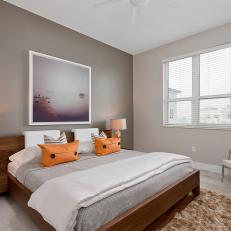 Minimalist, Modern Bedroom Design With Asian Wood Bed Frame, Cool Tone Color Scheme and Orange Accent Pillows
