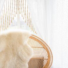 Refreshing Sitting Space With Woven Chair, Fur Decorative Throw and White Curtains With Beaded Fringe 