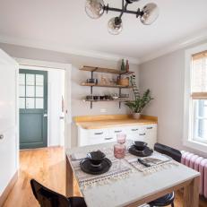 Cozy, Eat In Kitchen With Mounted Shelf Storage, Metal Light Fixture and Tasseled Placemats Over the White Tabletop 