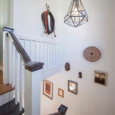 Twisting Staircase With Dark Polished Wood Steps, Striped Stair Runner and Diamond Pendant Light 