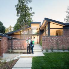 Attractive Home Brick Exterior With Concrete Walkway, Wood Garage Doors and Glass Window Paneling 