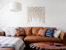 Contemporary Living Room With Southwestern Influence Featuring Leather Sectional and Macrame Art