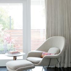 Window Sitting Space With Upholstered Midcentury Modern Chair and Matching Ottoman and Dark Hardwood Floor 