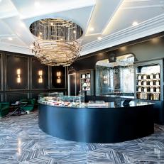 Art Decor Macaron Bakery With Dimensional Ceiling, Brass Chandelier, Crescent Counter and Black and White Floor 