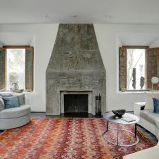 Spacious, Contemporary Living Room With Tall, Stone Fireplace Surround, Large Crescent Sofa and Warm Tone Pattern Rug