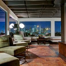 Dim, Stylish Dining Area With Skyline View, Plush Green Chairs and Red Stone Flooring 