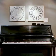 Black Piano in Front of Gray Wall With Black and White Wall Art 