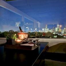 Romantic Dining Setting With City Line Window View, Dark Table With Bench Seating and Candle Centerpiece 