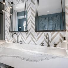 Master Bathroom Features Herringbone Tile Wall and Marble Sink