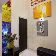Contemporary Foyer With Bright, Colorful Wall Art, Black Leather Bench and Dark Wood Door