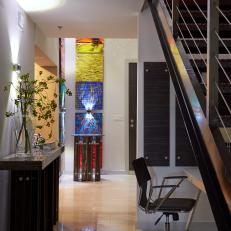 Contemporary Hallway With Polished Tile Floor, Desk Space Under the Stairs and Colorful Wall Art 