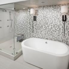 Gray and White Tile Accent Wall Behind Spacious Glass Shower and Modern White Tub 