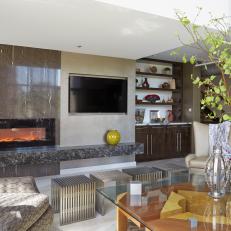 Sleek, Contemporary Living Room With Gray Stone Fireplace Surround, Glass Coffee Table and Mixed Seating Options 